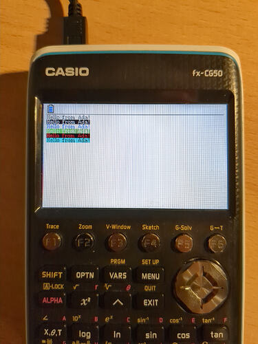 Image of the Casio fx-CG50 running my program written in Ada. On the screen is "Hello from Ada!" written 6 times in various color combinations.
